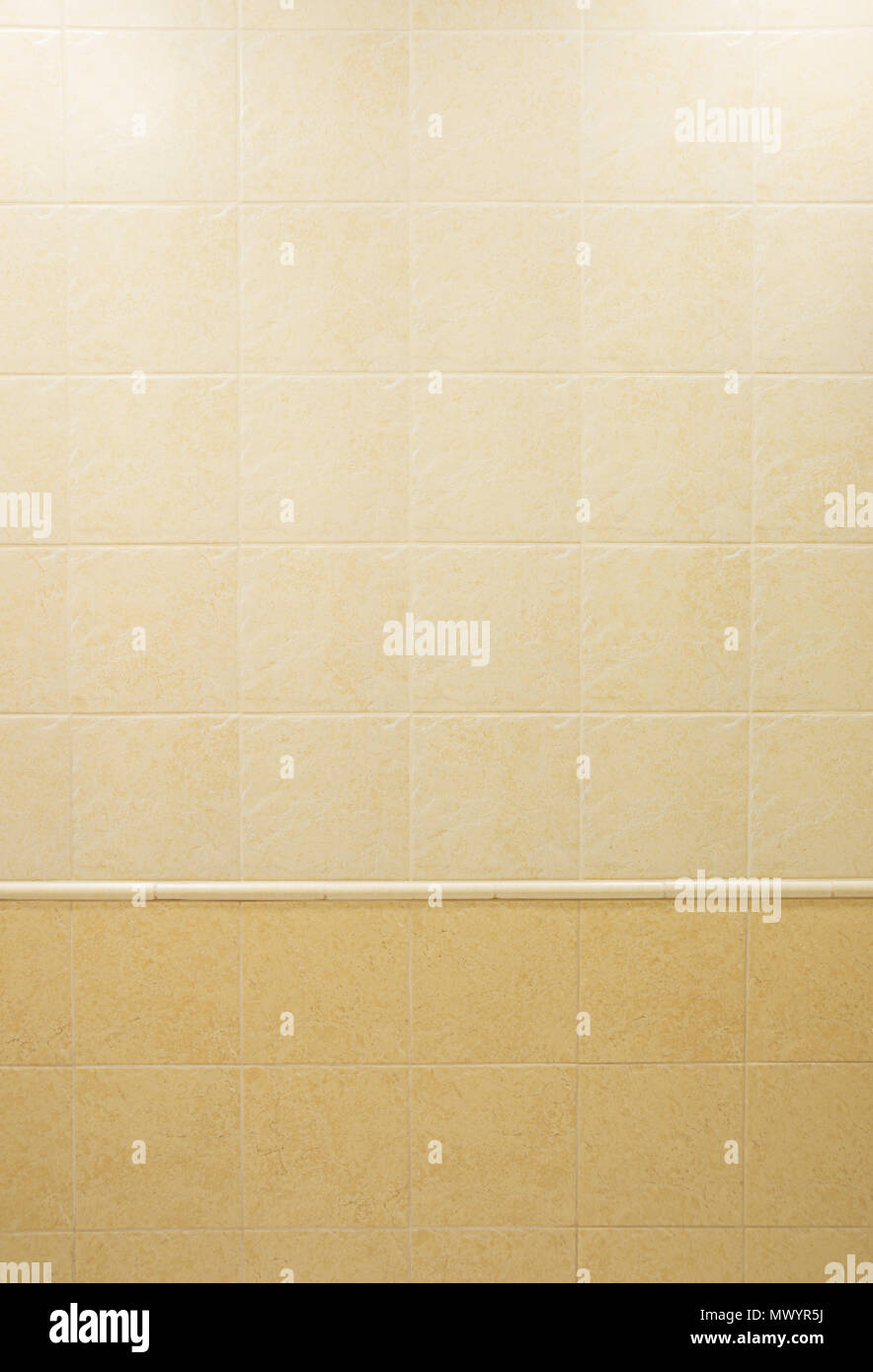Muro del bagno, finito con quadrato beige piastrelle di ceramica con un pattern di marmo di tonalità chiare e scure. Sfondo architettonico Foto Stock