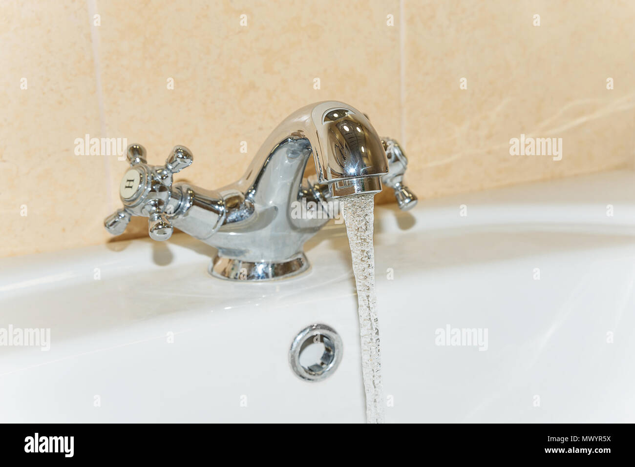 Acqua potabile pulita fluisce da un acciaio rubinetto del bagno Foto Stock