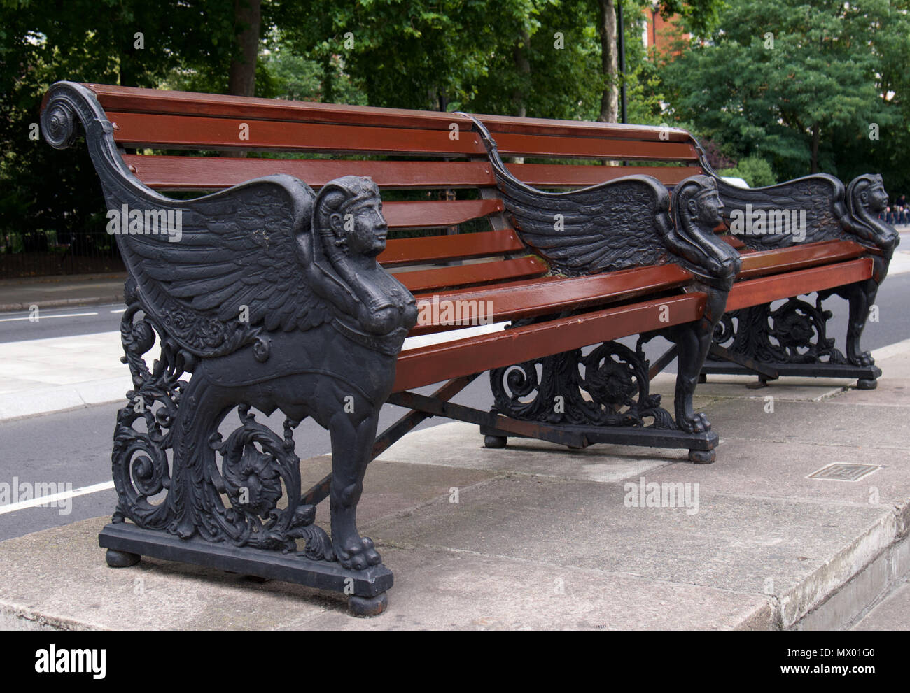 Panca in legno con design egiziano accanto a Cleopatra Needle, Londra Foto Stock