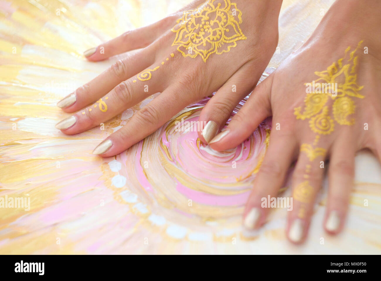 Due open vuoto Mehndi le mani con i palmi verso il basso isolato su sfondo dipinto. Modello di oro. Arte terapia. Foto Stock