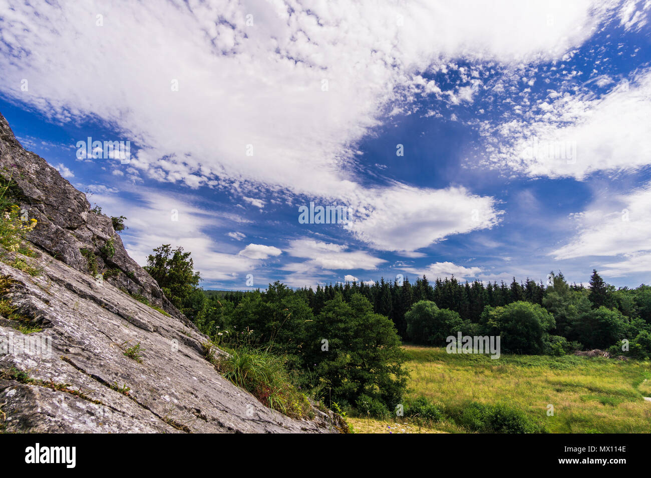 Nuvole paesaggio verde albero rock Bel cielo Foto Stock
