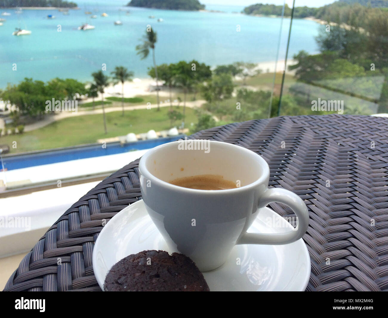 PULAU Langkawi, Malesia - 4 APR 2015: una tazza di caffè e dei cookie sul tavolo con mare in background Foto Stock