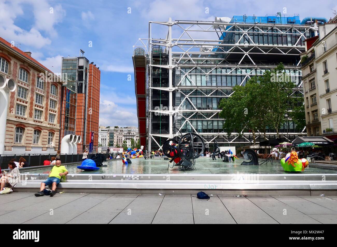 Parigi, Francia. Luminosa calda soleggiata giornata di primavera, maggio 2018. Le persone che si godono le fontane e arte presso la Place Igor Stravinsky vicino al centro Pompidou. Foto Stock