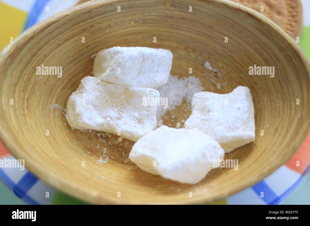 Cubi Loukoum coperti in bianco powedered zucchero in un piatto di legno. Foto Stock