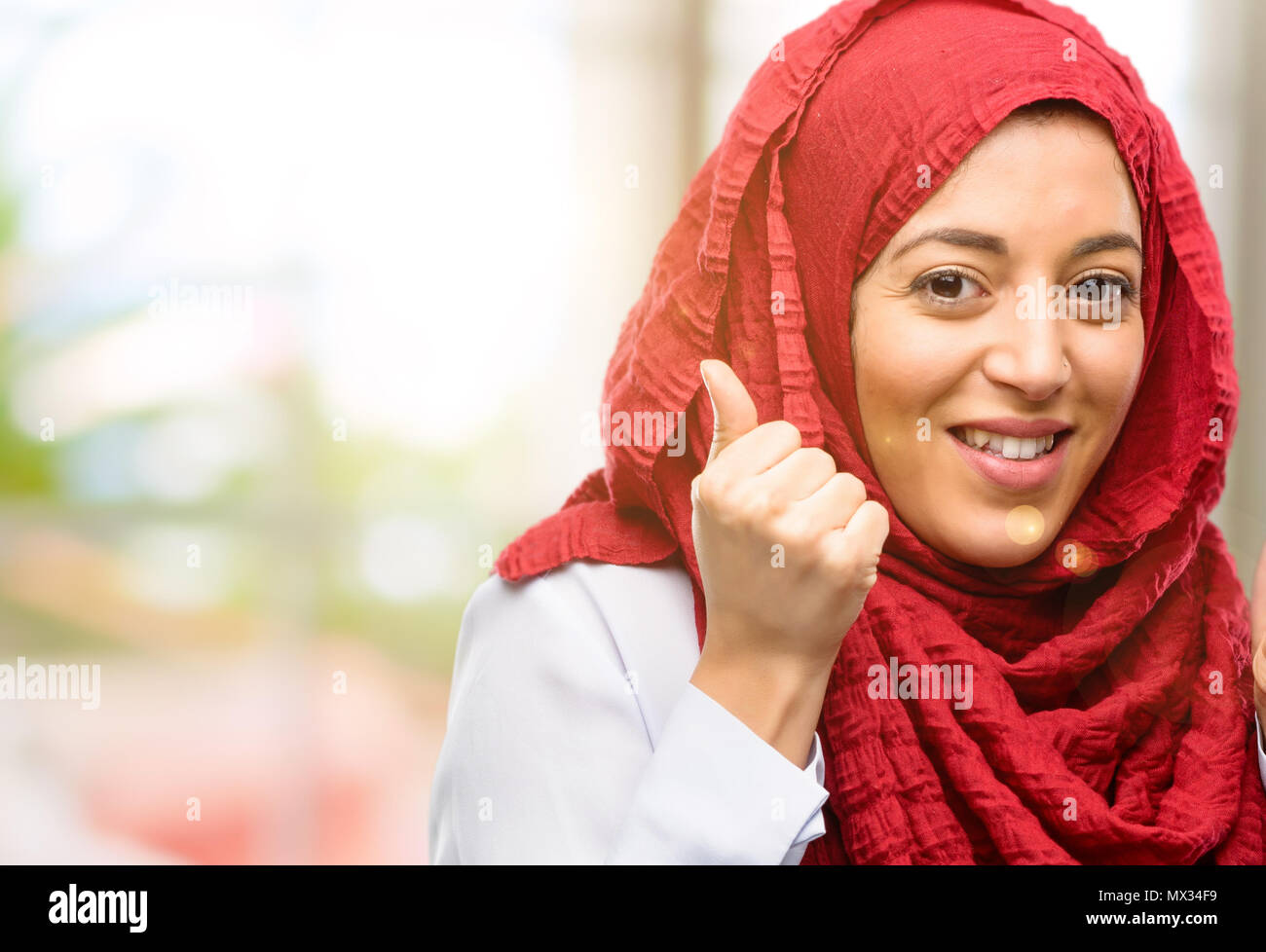 Giovane donna araba indossa hijab felice e sorpreso il tifo esprimenti il gesto di wow Foto Stock