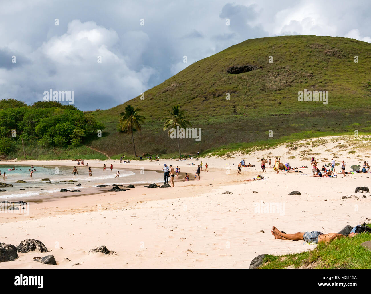 Persone su Anakena curvo Sandy Bay Beach L'Isola di Pasqua, Rapa Nui, Cile, con nuvole di tempesta Foto Stock