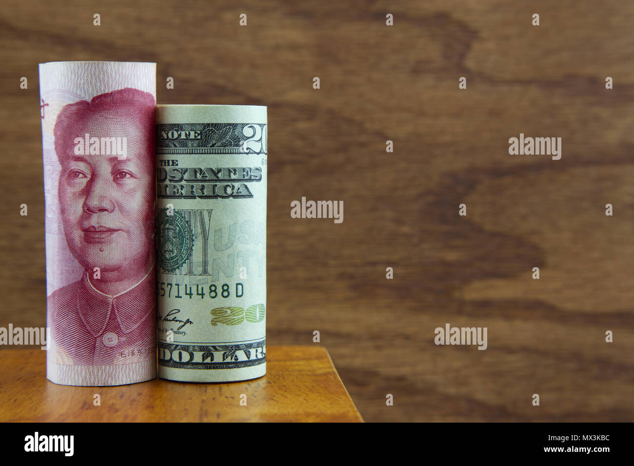 Dollaro americano e yuan cinese messo insieme contro uno sfondo di legno simboleggia un integrato ambiente aziendale Foto Stock