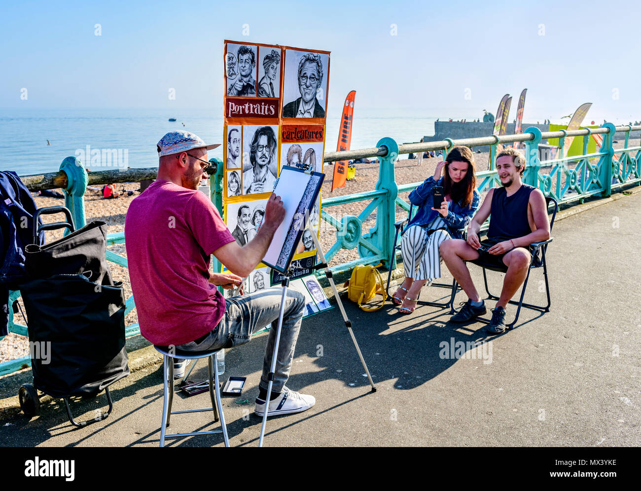 Matura in posa per una caricatura artista sul lungomare di Brighton Regno Unito Foto Stock