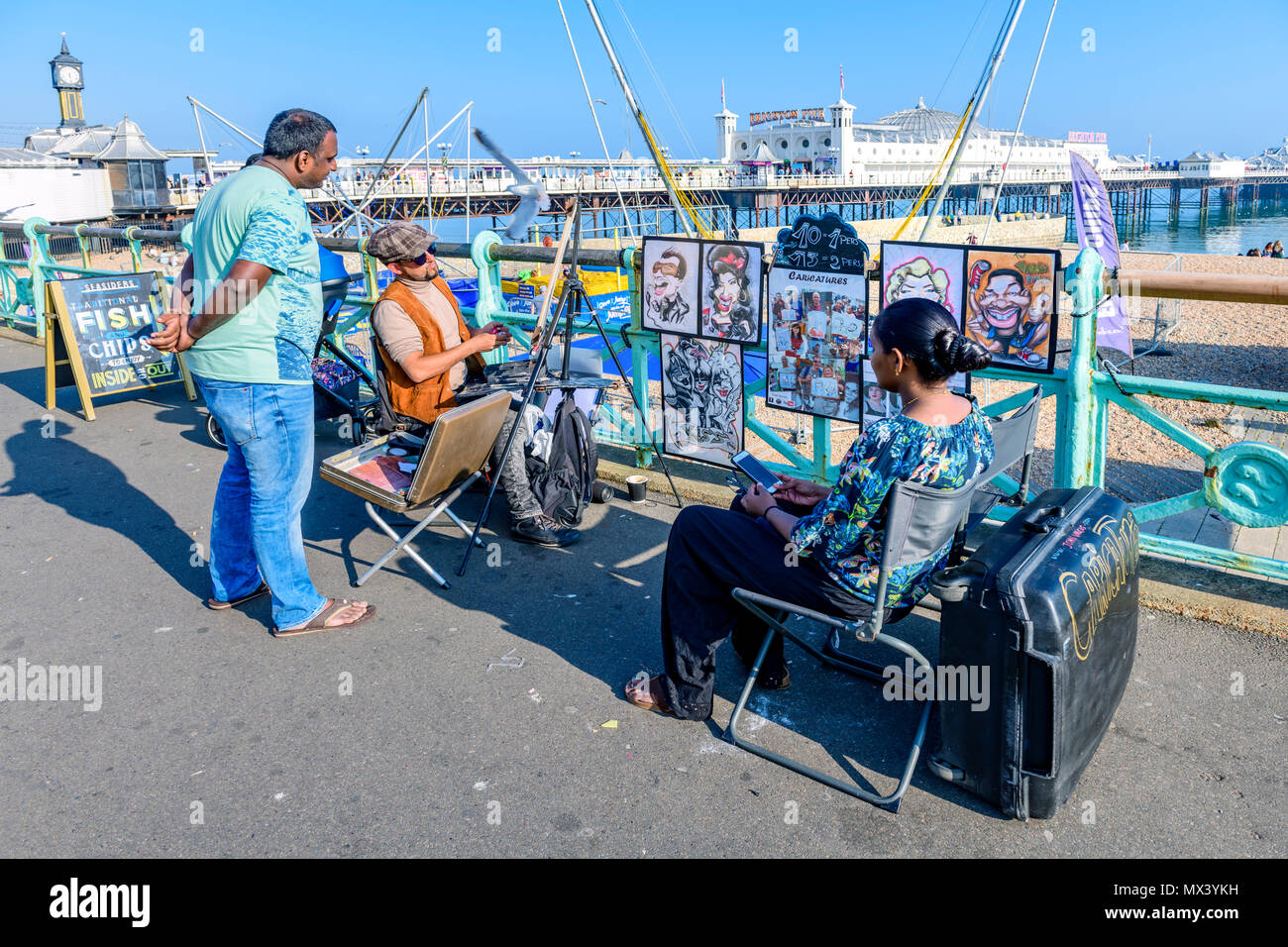 La donna posa per una caricatura artista sul lungomare di Brighton Regno Unito Foto Stock