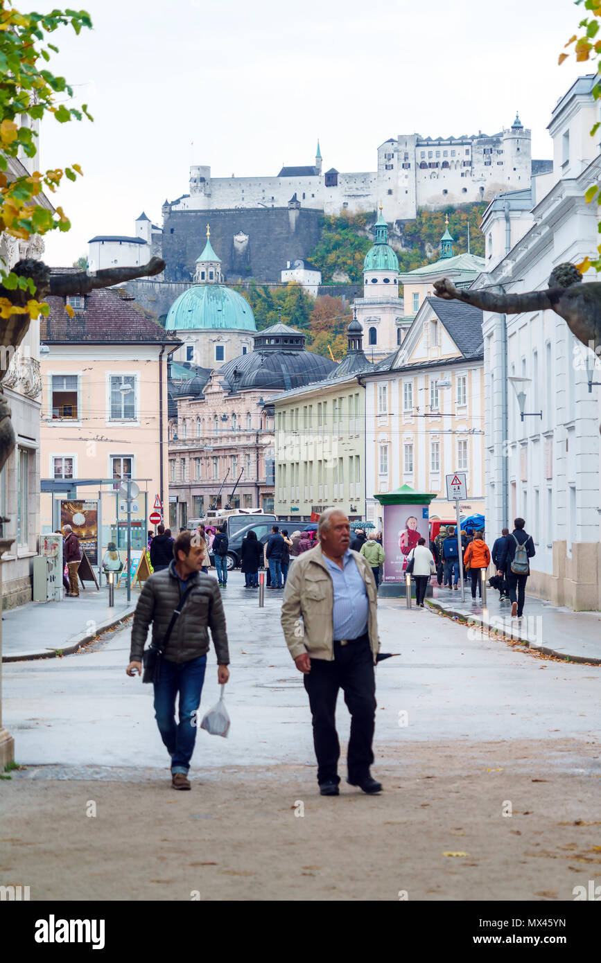 Salisburgo, Austria - 21 Ottobre 2017: i turisti e la gente del posto a piedi attraverso le strade della città vecchia sotto la pioggia contro lo sfondo della Hohensalzbu Foto Stock