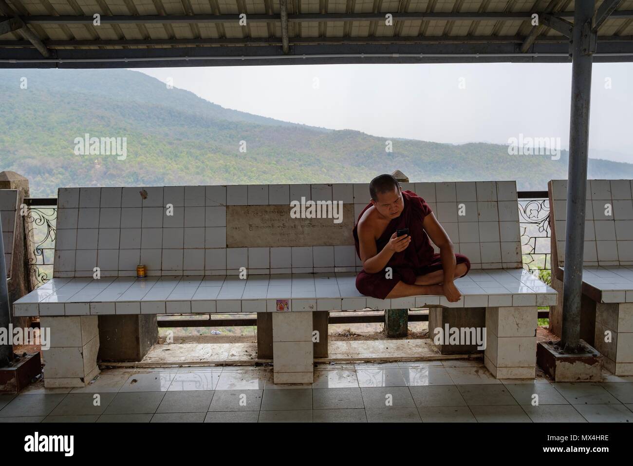 I monaci buddisti utilizzando i telefoni intelligenti, il Monte Popa vicino a Bagan, Myanmar Foto Stock