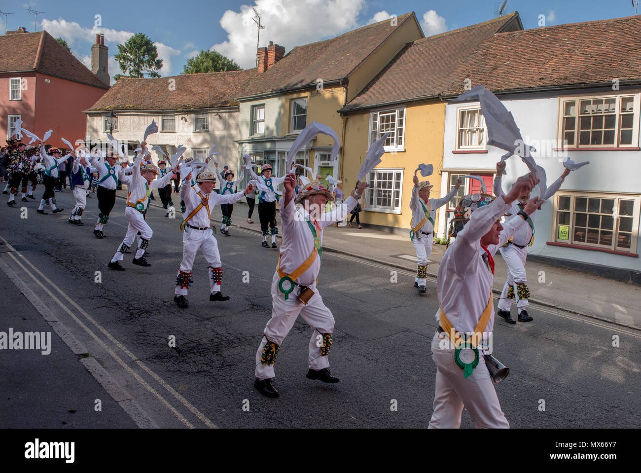 Thaxted Morris Weekend, Thaxted Essex England Regno Unito. 2-3 Giugno 2018 La 85a Assemblea degli Stati Club dell'anello di Morris ospitato da Thaxted Morris (uomini che indossano strisce rosse e bianche) che portano il sabato sera processione per Town Street in Thaxted dopo un giorno occupato di ballare in una dozzina di pub locali nei circostanti villaggi nel nord-ovest dell' Essex. Lincoln e Micklebarrow in giallo e verde in città Street Thaxted. Credito: BRIAN HARRIS/Alamy Live News Foto Stock