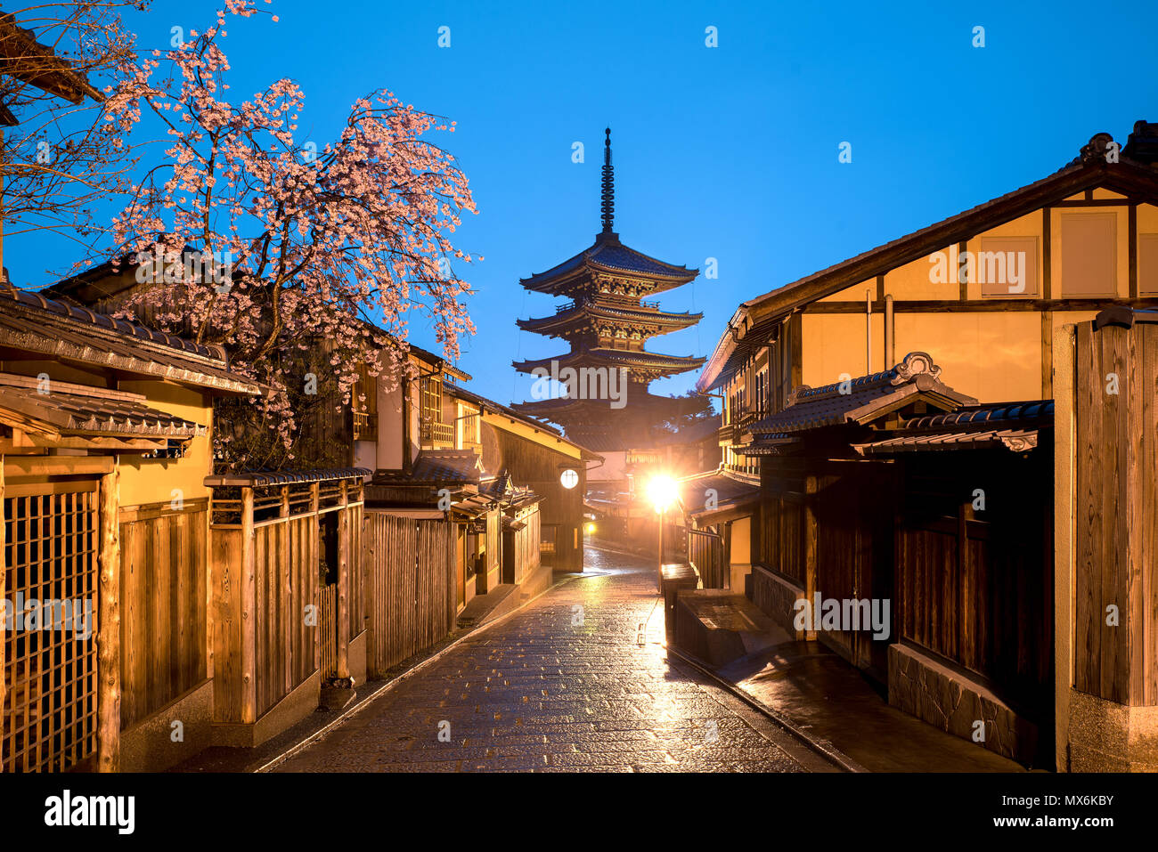 La pagoda giapponese e la vecchia casa con la fioritura dei ciliegi a Kyoto al crepuscolo. Foto Stock