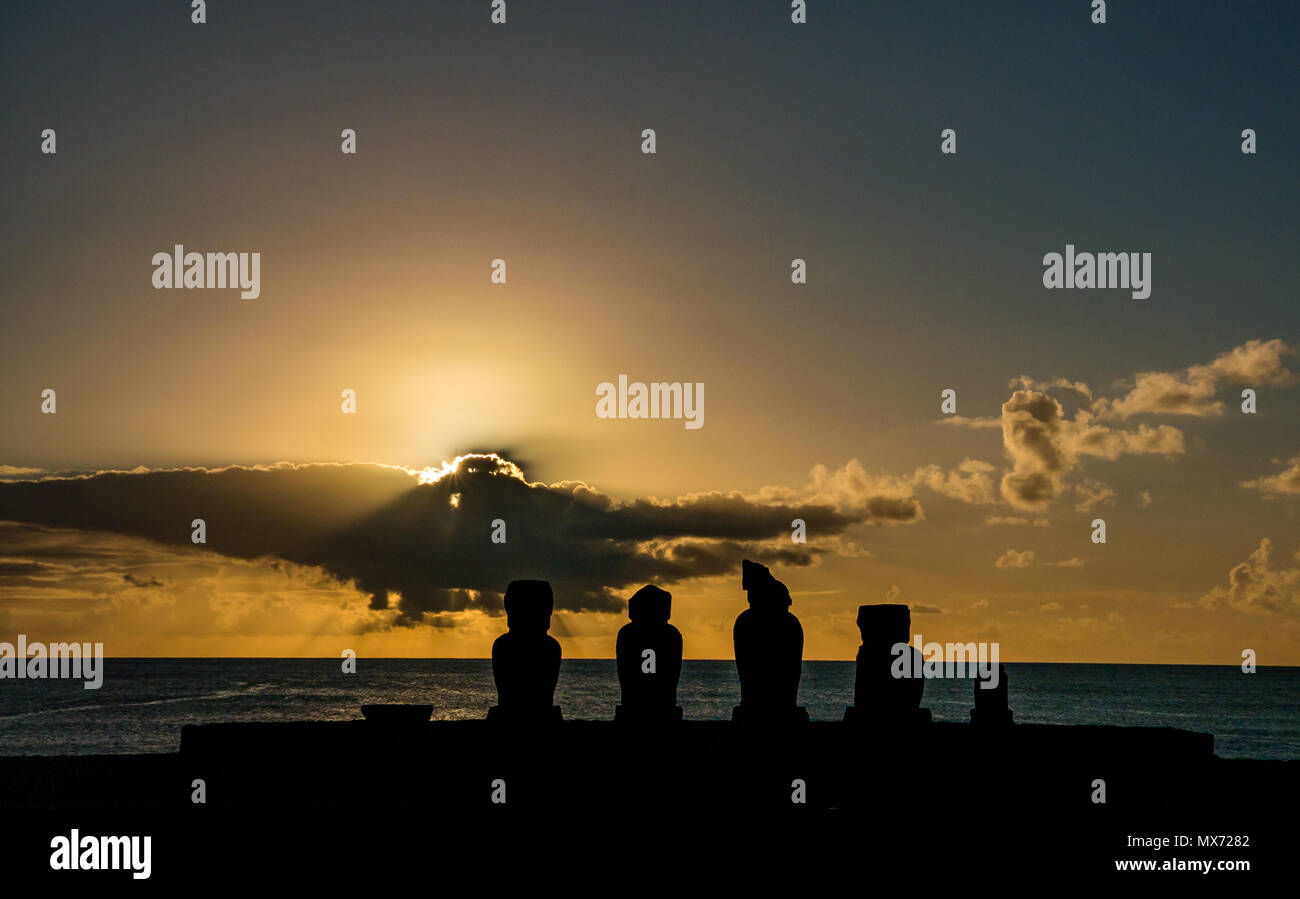 Spettacolare tramonto arancione colorato e sunburst con le silhouette AHU Moai, Tahai, Isola di Pasqua, Rapa Nui, Cile Foto Stock