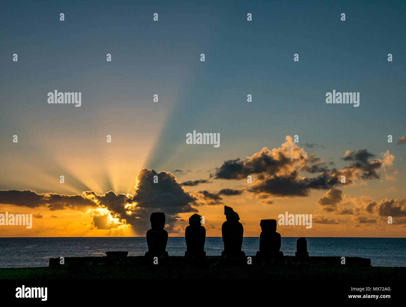 Spettacolare tramonto arancione colorato e luce sunburst con le silhouette AHU Moai, Tahai, Easter Island, Rapa Nui, Cile Foto Stock