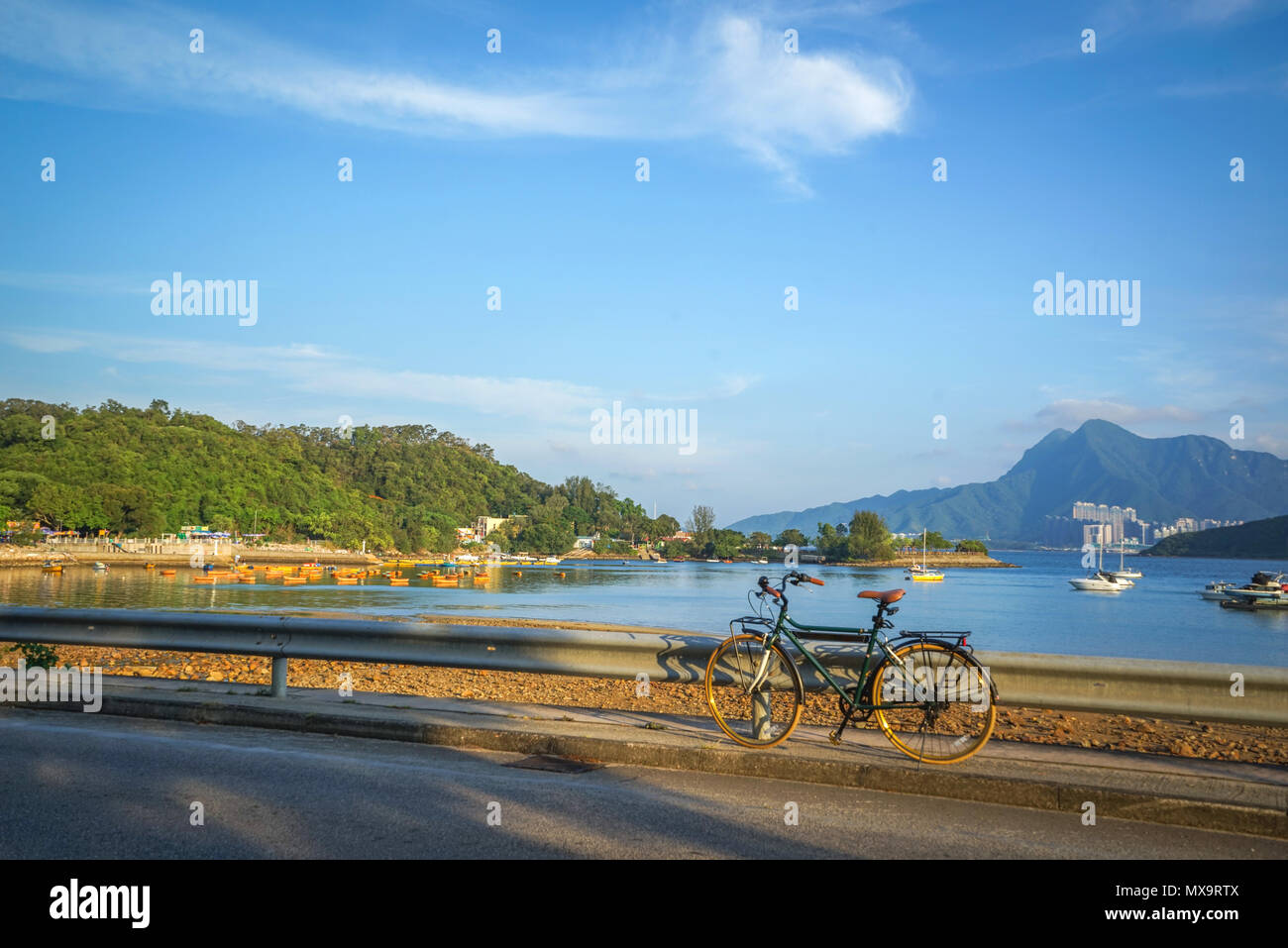 Bicicletta retrò marrone con il sedile in pelle, montagne, lago e cielo blu Foto Stock