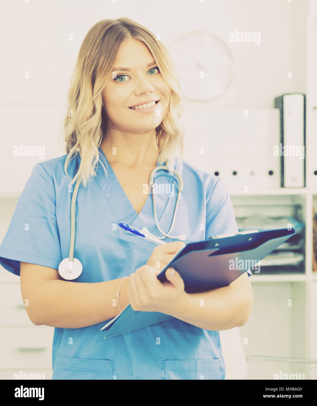 Ragazza medico sorge nei pressi di un tavolo in ufficio Foto Stock