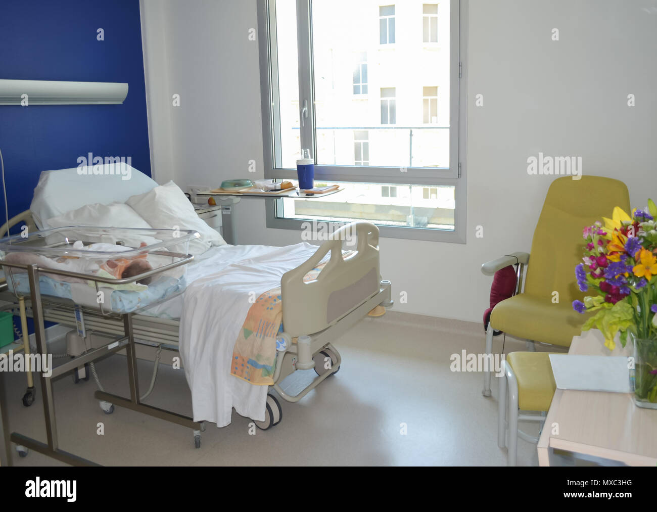 Ospedale vuoto camera con un letto per il paziente e il neonato vicino al letto Foto Stock