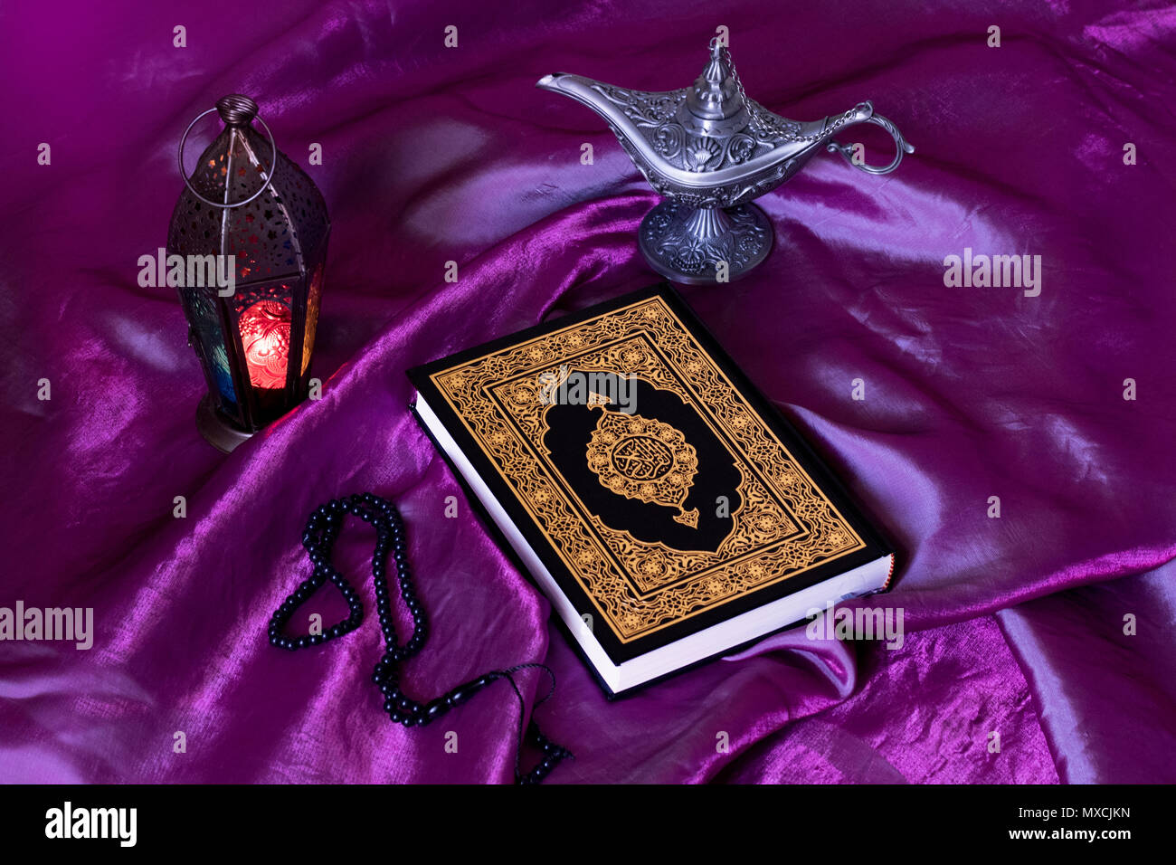 Santo libro islamico Corano su Viola tessuto di seta con un rosario,Lanterna ed Egitto lampada Aladdin - Ramadan kareem/l'Eid Al Fitr concetto. Foto Stock