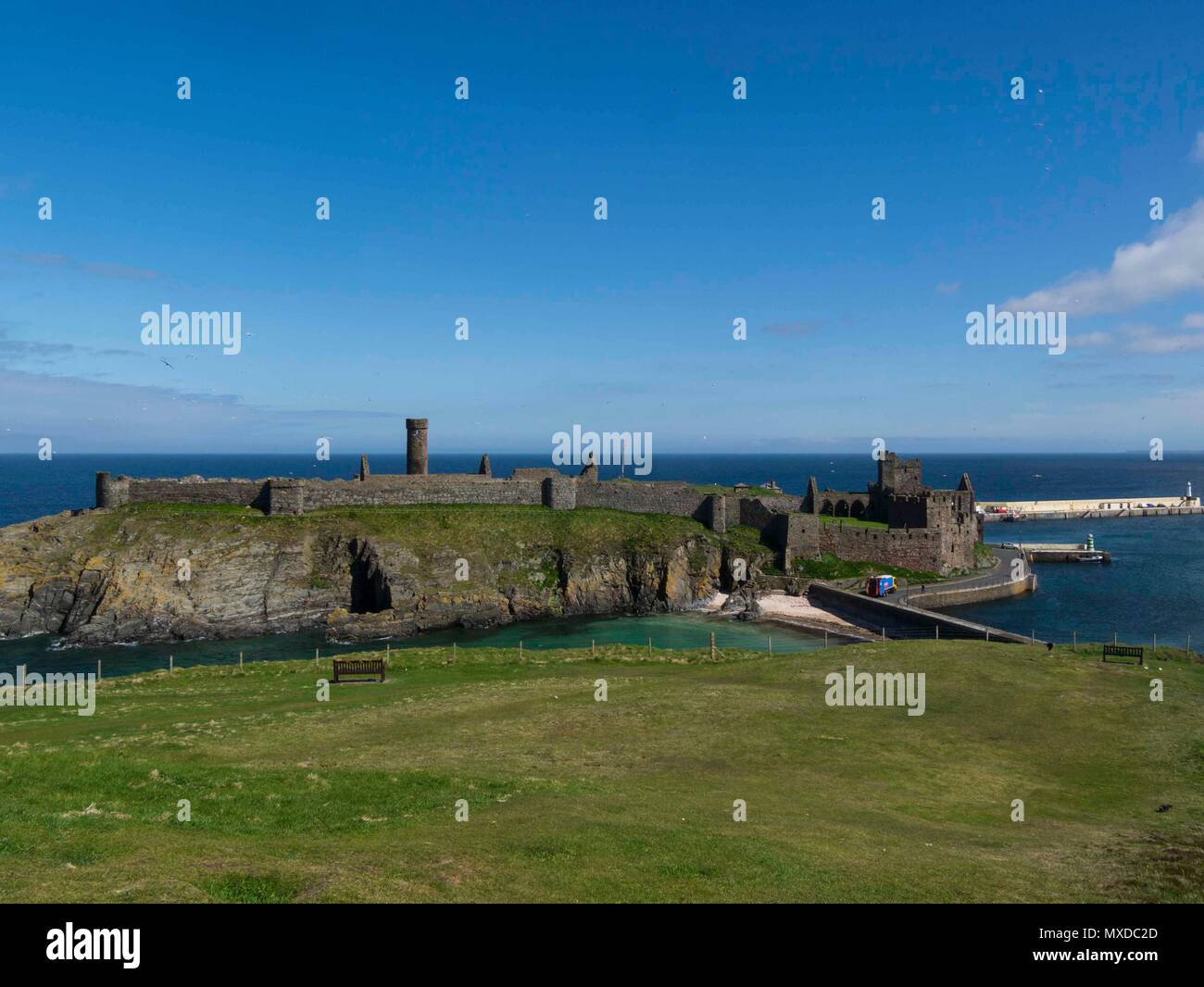 Imponente castello di pelatura su San Patrizio isola unita alla città da causeway round tower precedentemente parte del monastero celtico Peel Isle of Man visto dalla buccia Foto Stock