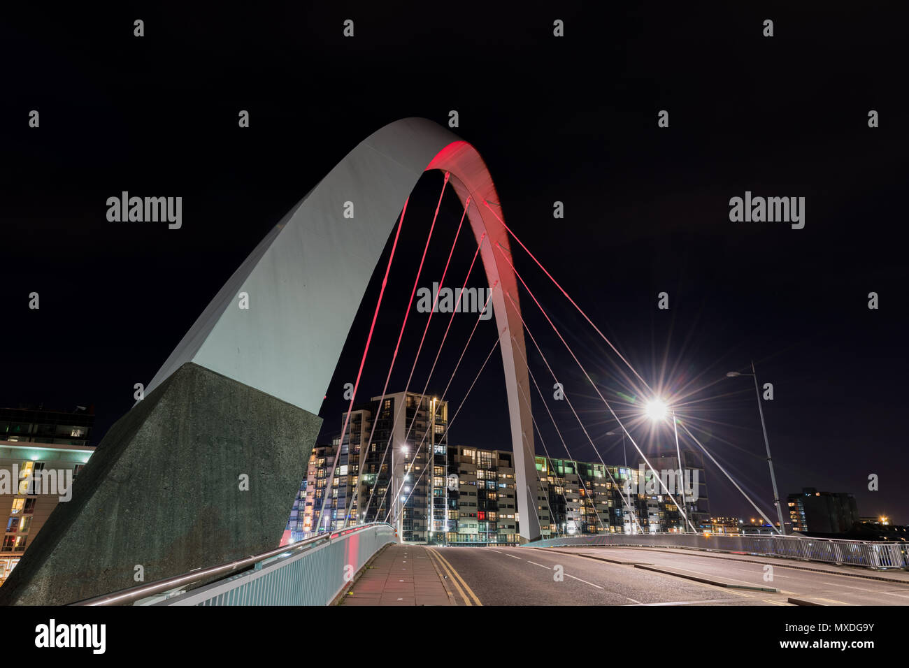 Il Clyde Arc Bridge (Ponte Squinty) durante la notte con una chiara road Foto Stock