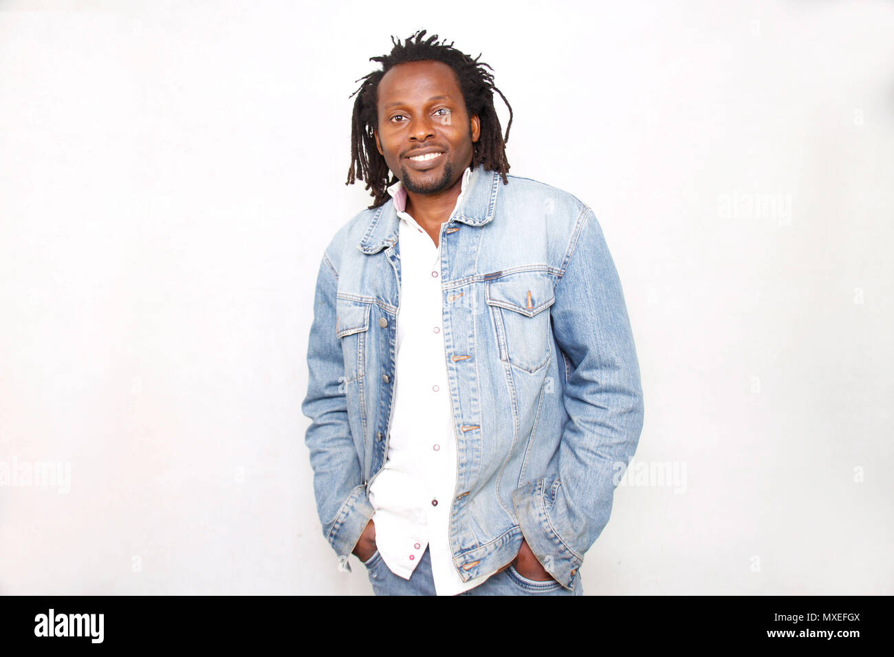 African American uomo con Dreadlocks camicia bianca e sorridente a voi dal suo cuore Foto Stock