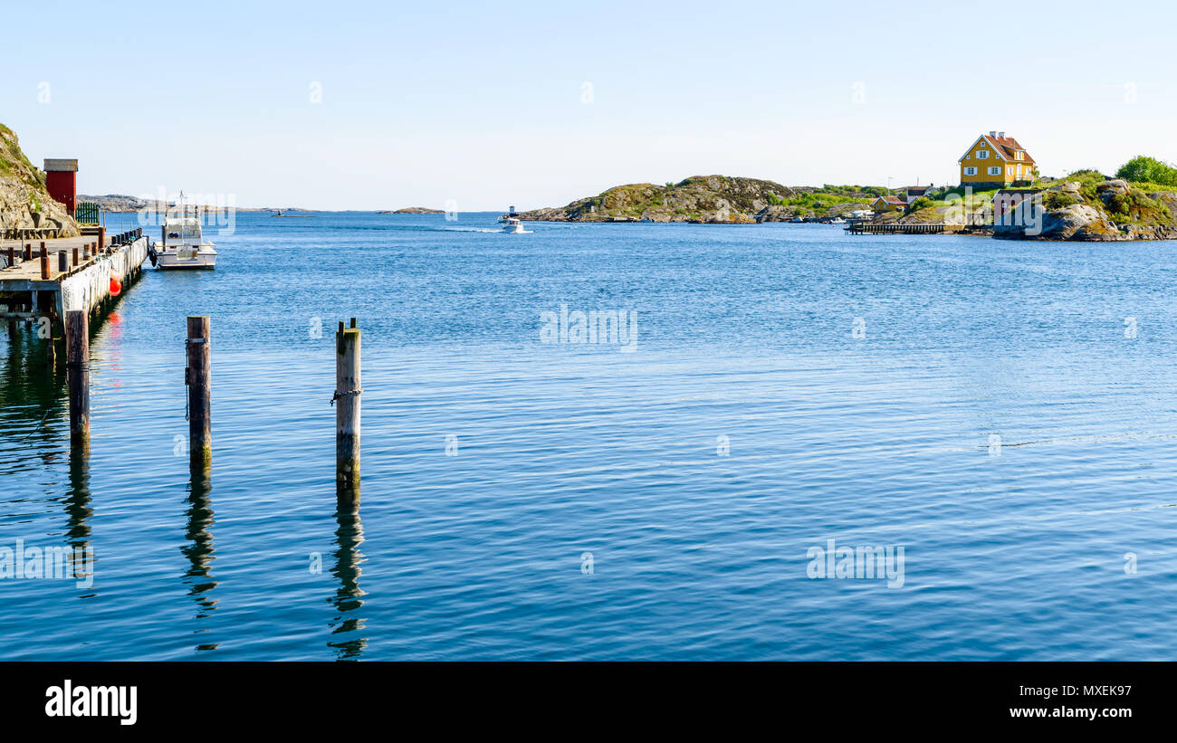 Barche passando in stretto Kyrkesund fuori Tjorn sulla svedese costa ovest su un soleggiato e clam giorno. Foto Stock