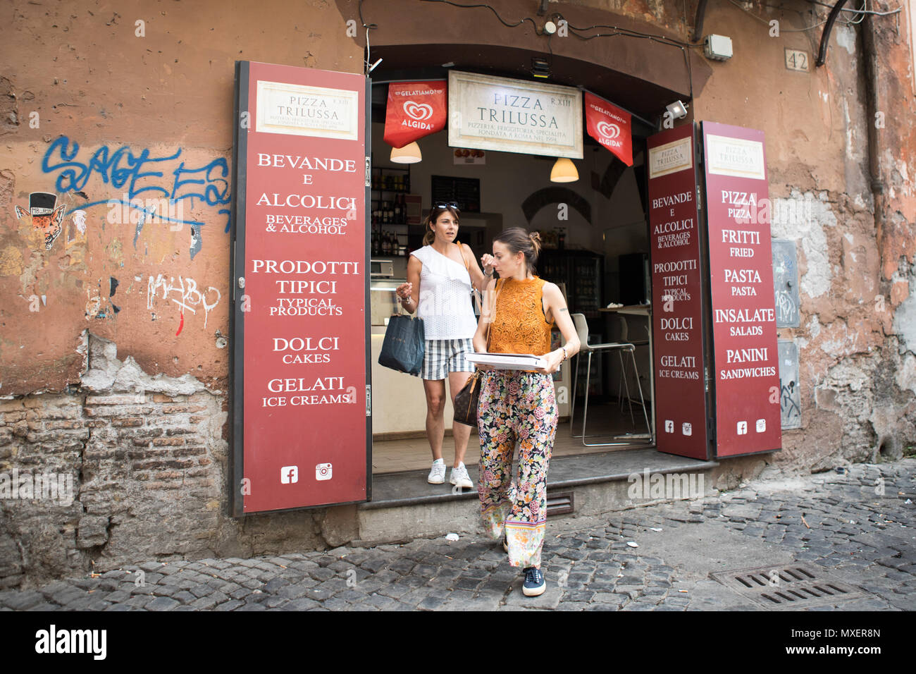 Pizzeria a Trastevere, Roma, Italia , le donne portano via la pizza al mattino. Foto Stock