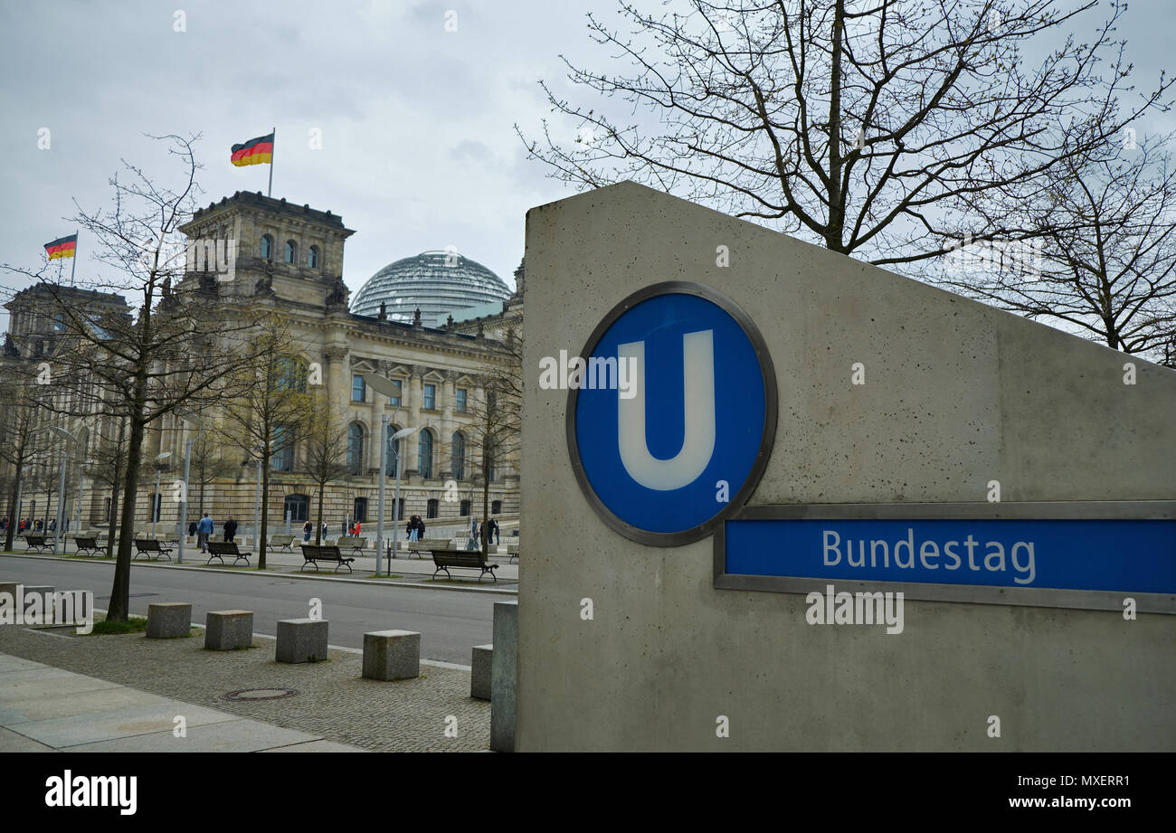 Berlino, Germania - 14 Aprile 2018: uscita del Bundestag U-Bahn stazione della metropolitana con road, alberi sfrondato e Edificio del Reichstag sullo sfondo Foto Stock