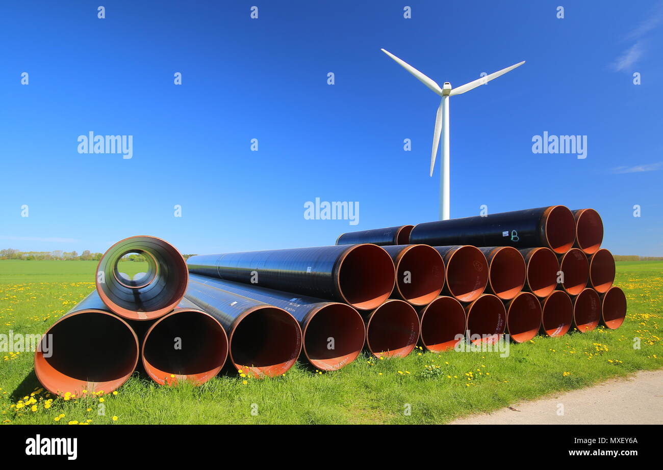 Cumulo di tubi di acciaio e wind power station in zona rurale nel Meclemburgopomerania Occidentale, Germania. Foto Stock