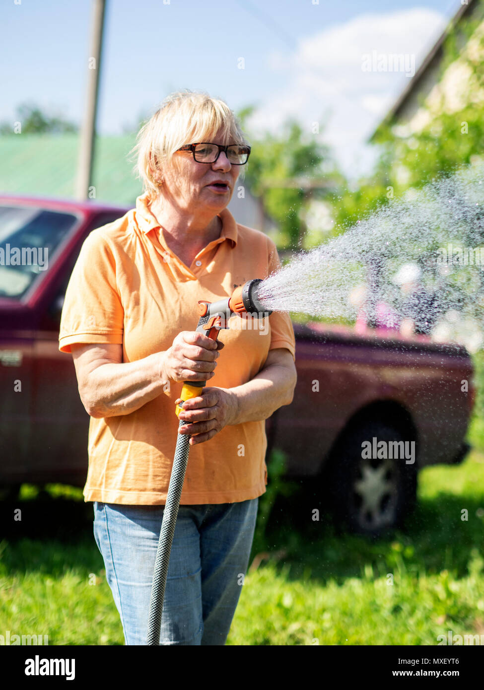 Di mezza età donna caucasica acquolina in giardino Foto Stock