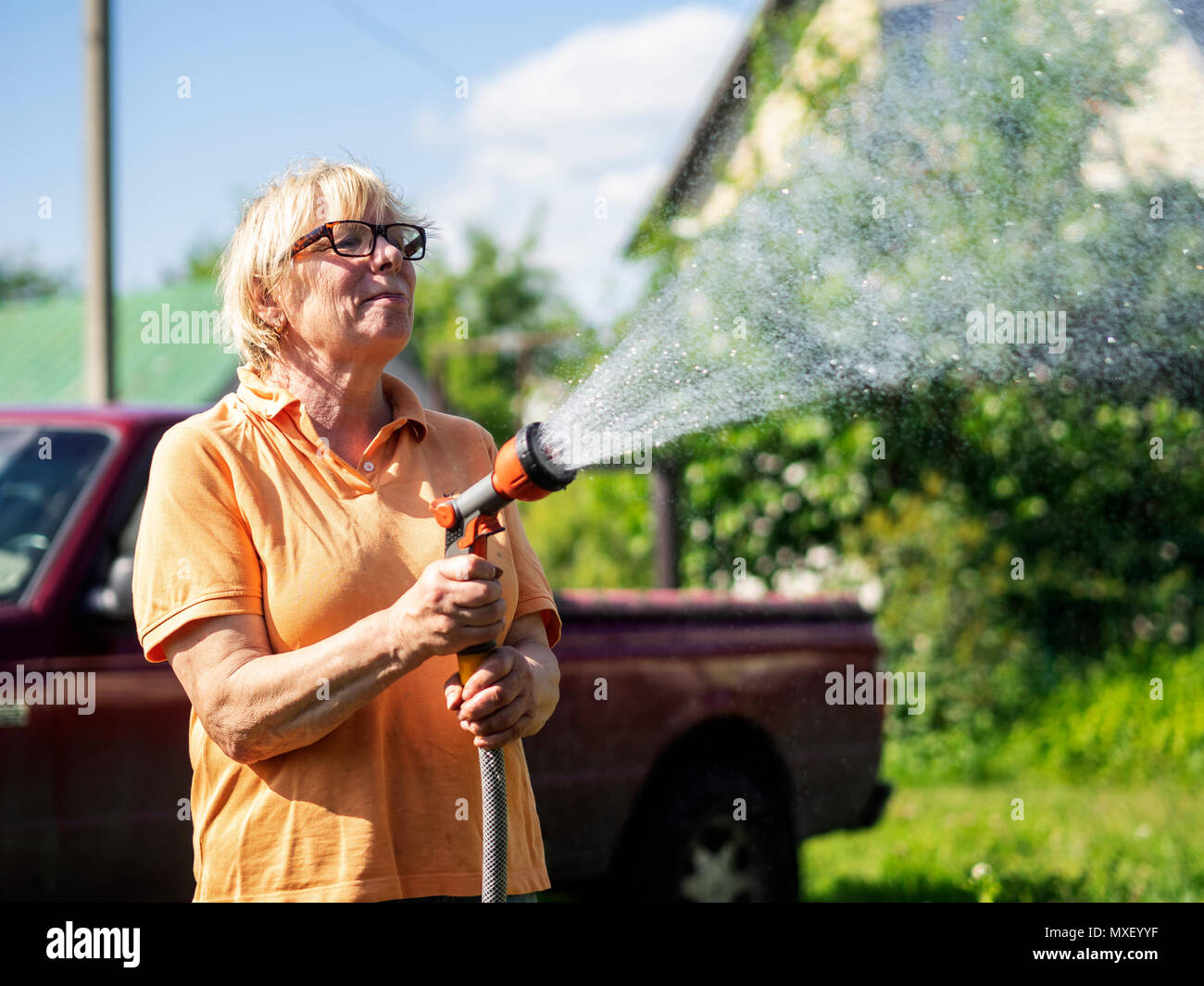 Di mezza età donna caucasica acquolina in giardino Foto Stock