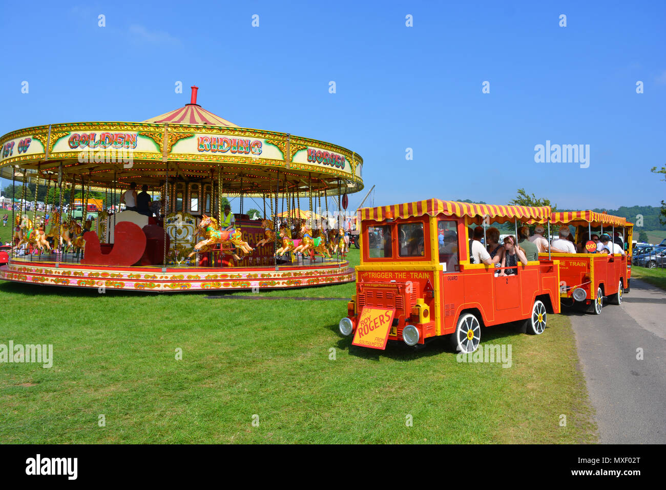 Merry-go-round e viaggio in treno a Sherborne Castle Country Fair, Dorset, Inghilterra Foto Stock