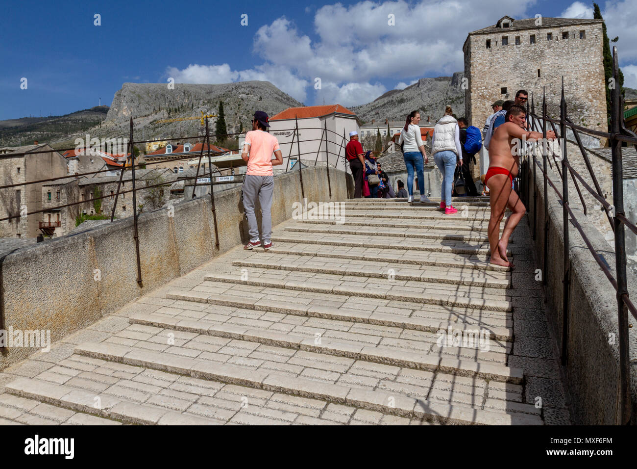 Un subacqueo in attesa per le donazioni prima di immersioni subacquee lo storico Stari Most (Ponte Vecchio) oltre il fiume Neretva a Mostar, in Bosnia ed Erzegovina. Foto Stock