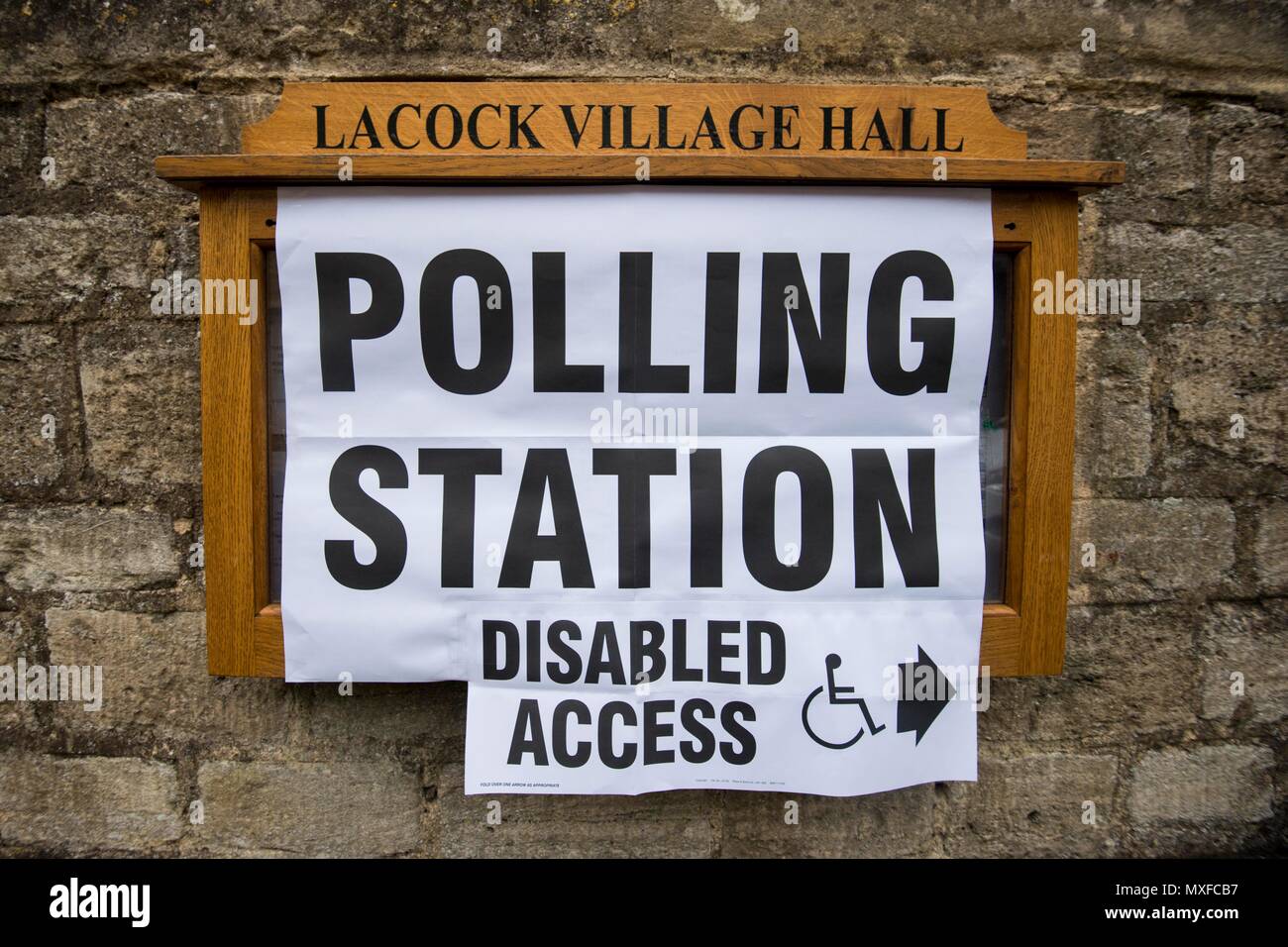 La gente va a poli nell'elezione generale 2017 foto di un conservatore teller sorge al di fuori della stazione di polling a Lacock Village Hall Foto Stock