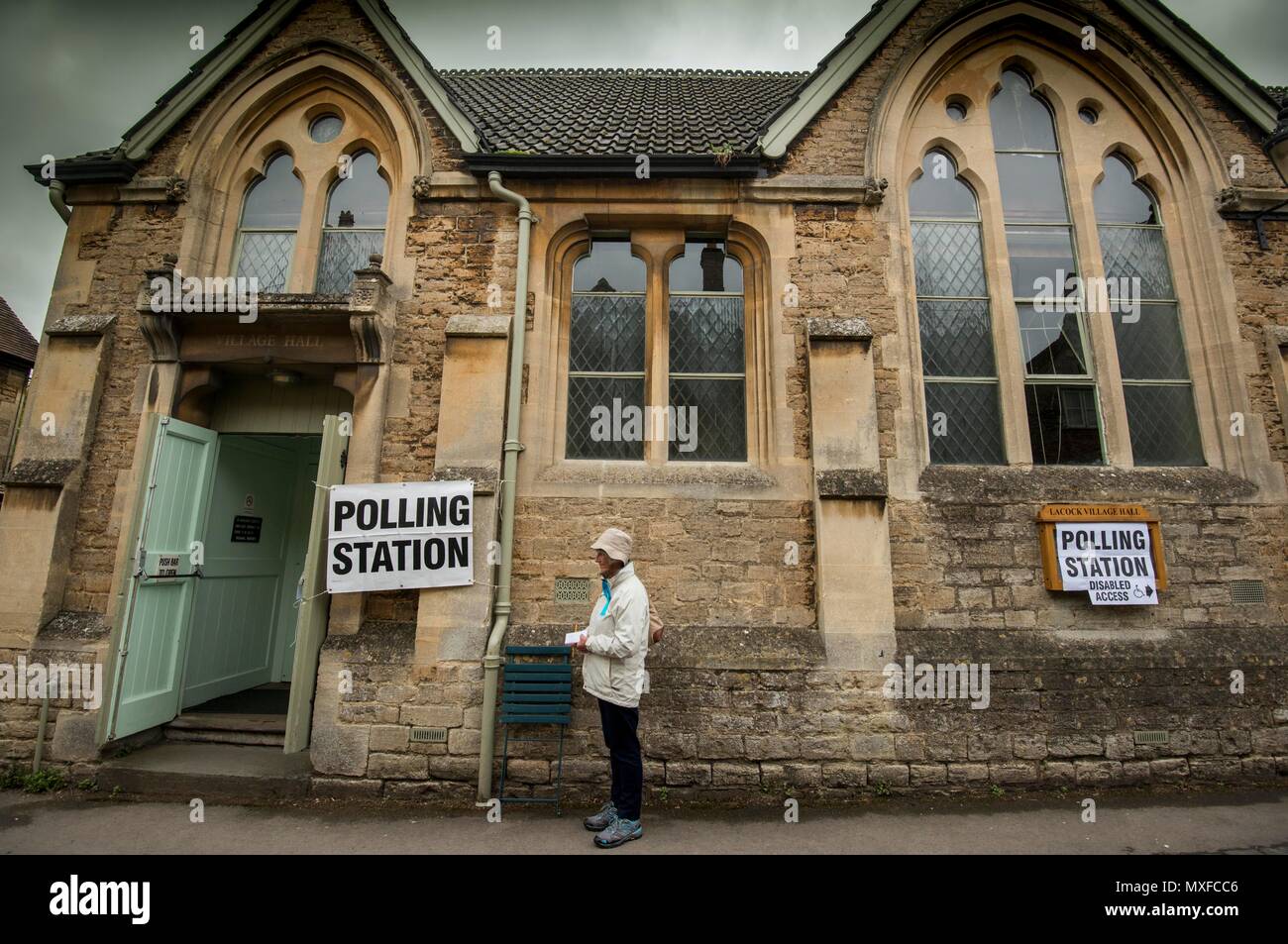 La gente va a poli nell'elezione generale 2017 foto di un conservatore teller sorge al di fuori della stazione di polling a Lacock Village Hall Foto Stock