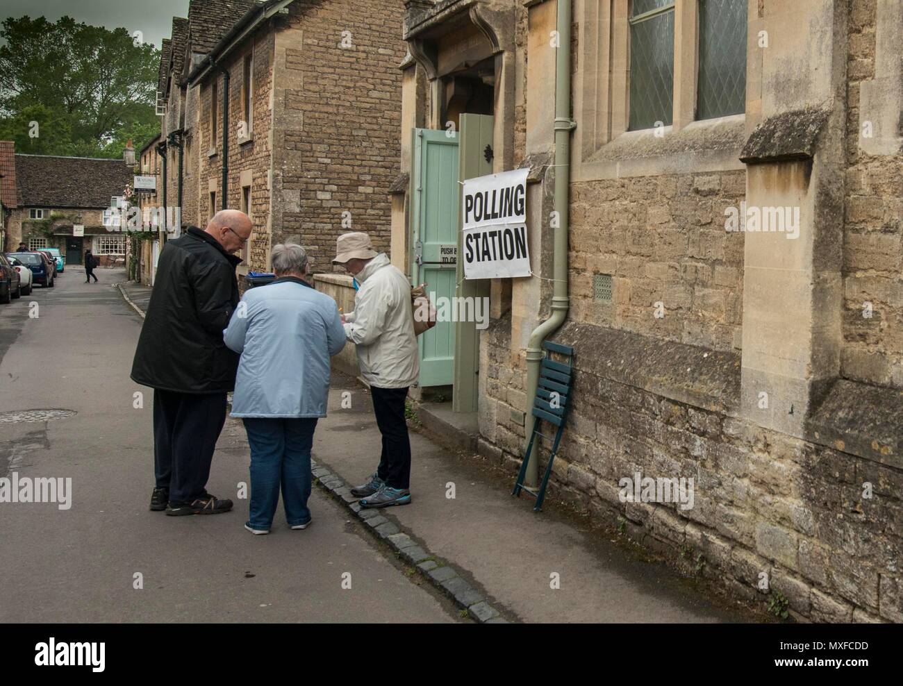La gente va a poli nell'elezione generale 2017 foto di un conservatore teller sorge al di fuori della stazione di polling a Lacock Village Hall Foto Stock
