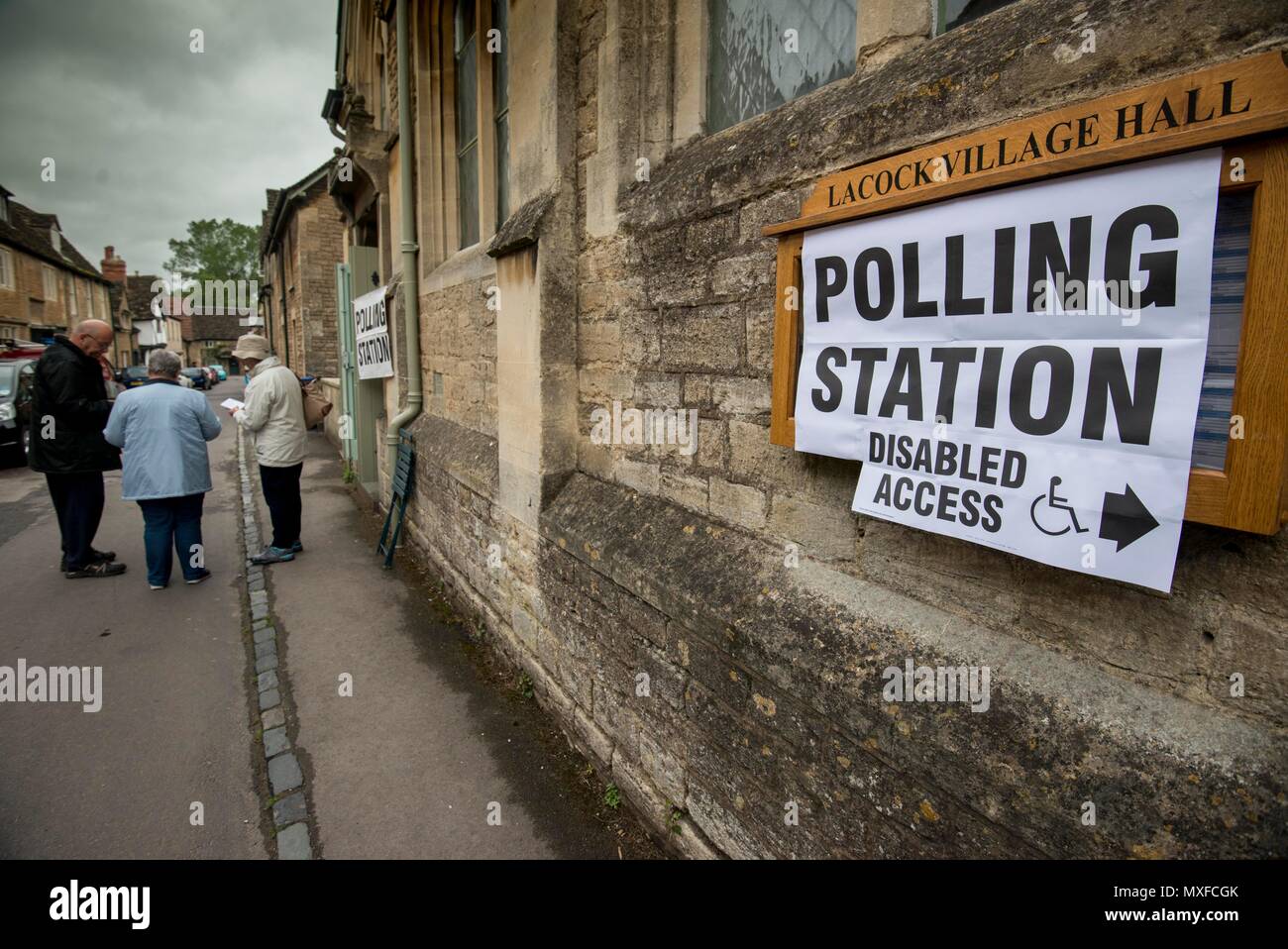 La gente va a poli nell'elezione generale 2017 foto di un conservatore teller sorge al di fuori della stazione di polling a Lacock Village Hall Foto Stock