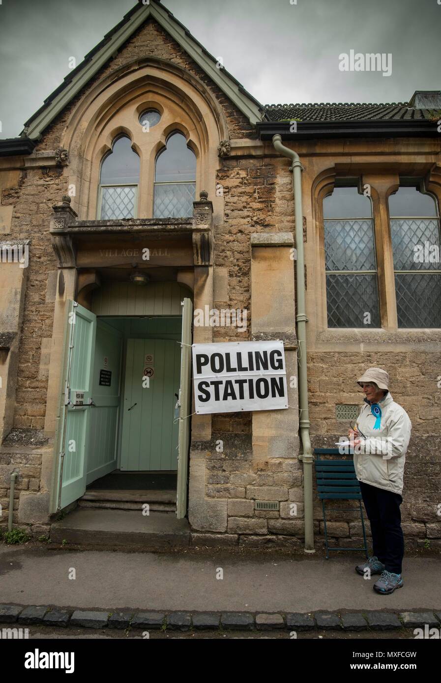 La gente va a poli nell'elezione generale 2017 foto di un conservatore teller sorge al di fuori della stazione di polling a Lacock Village Hall Foto Stock