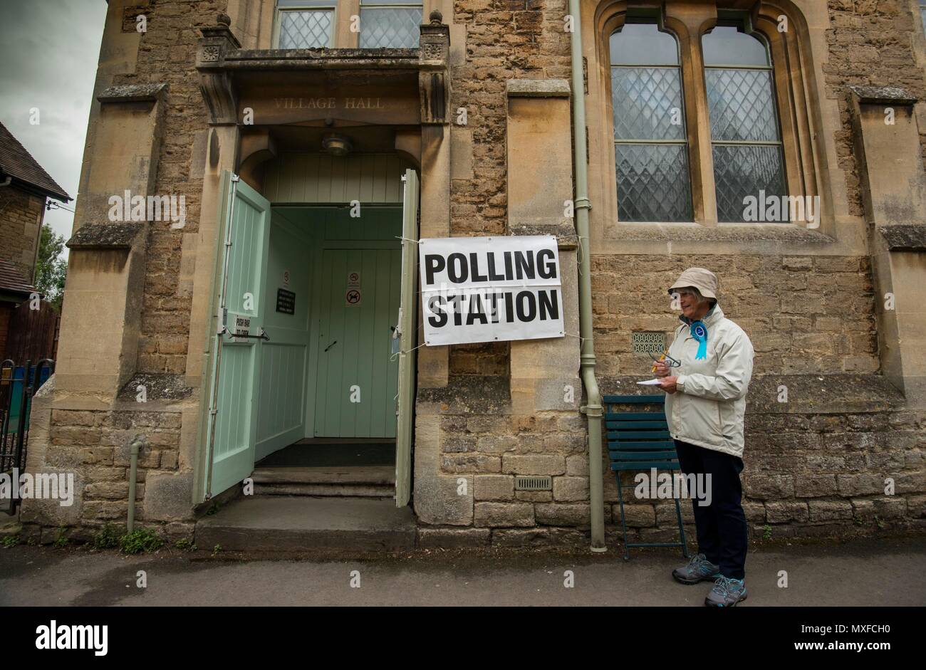 La gente va a poli nell'elezione generale 2017 foto di un conservatore teller sorge al di fuori della stazione di polling a Lacock Village Hall Foto Stock