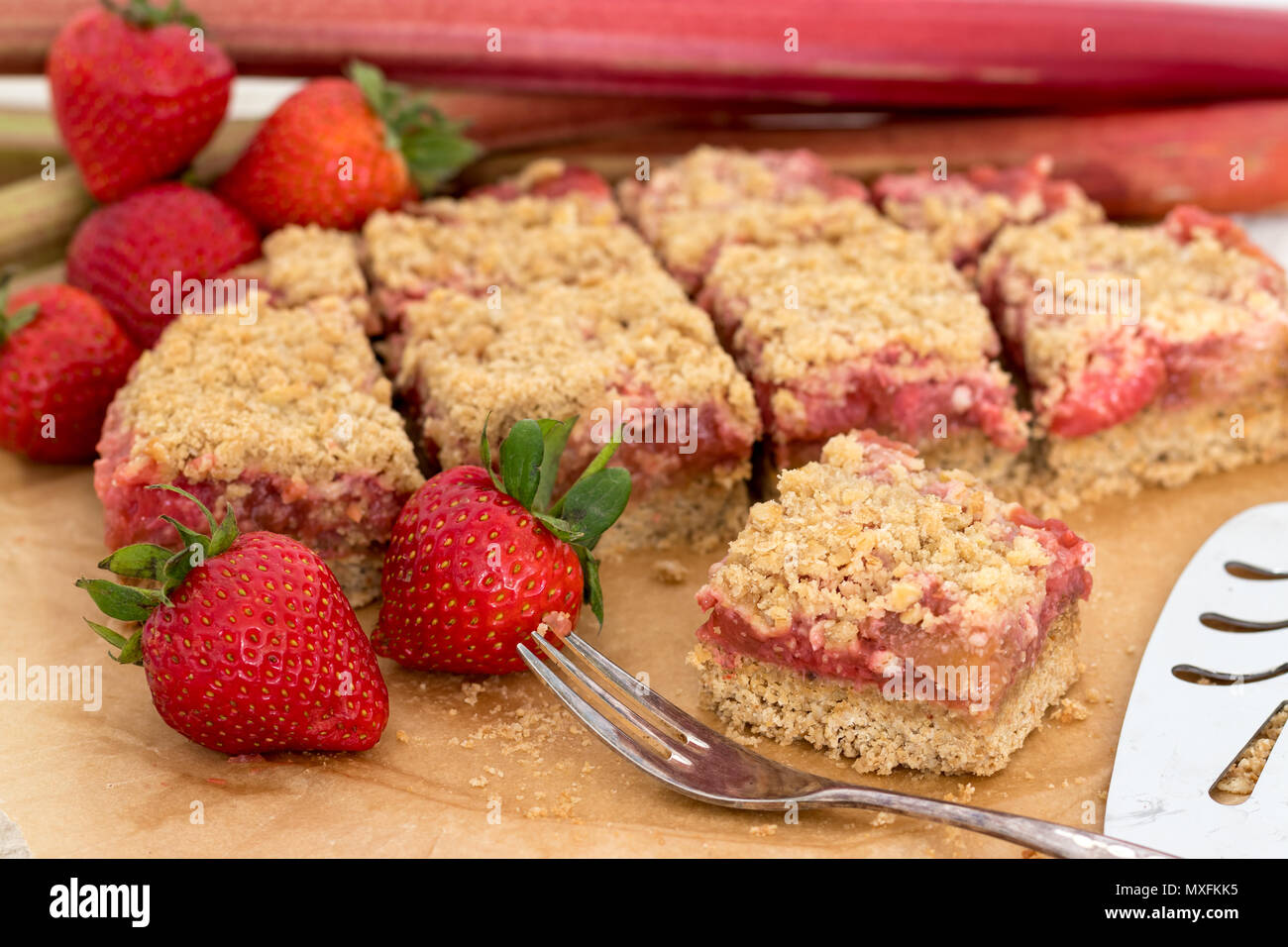 Delizioso e sano estate snack o dessert. In casa senza glutine di rabarbaro e fragola crumble fetta, fatta con frutta fresca. Foto Stock
