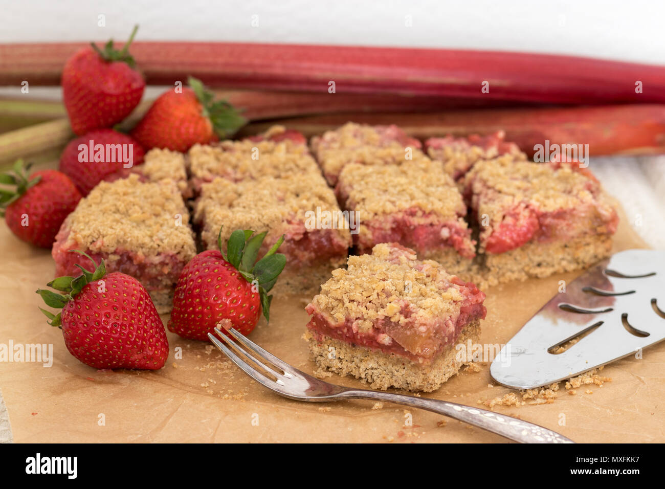 Delizioso e sano estate snack o dessert. In casa senza glutine di rabarbaro e fragola crumble fetta, fatta con frutta fresca. Foto Stock