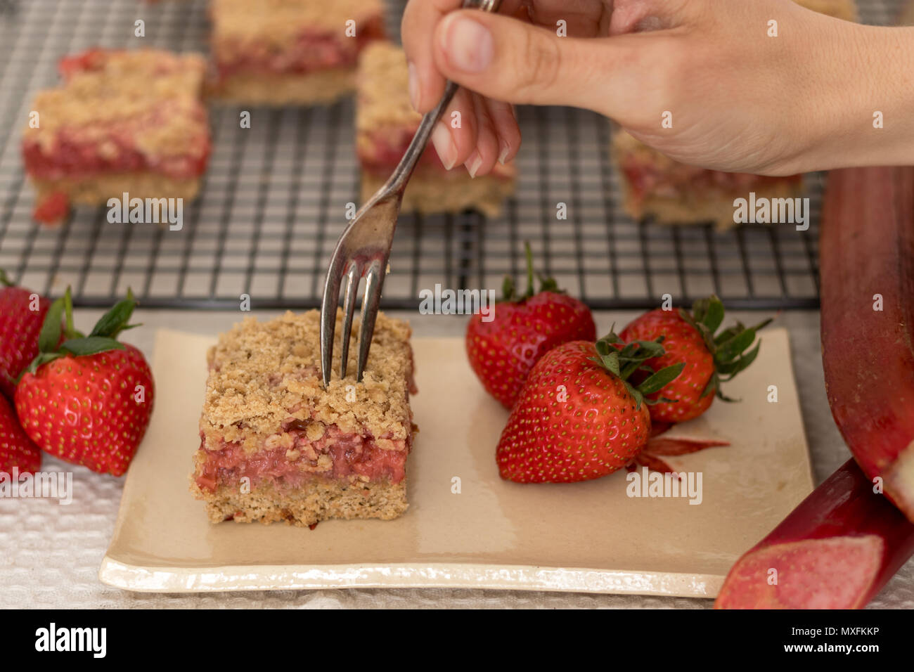 Fette di sani di rosso frutta estiva bar servita su un handmade piastra ceramica. Un delizioso pane appena sfornato dolci con fragole e rabarbaro. Foto Stock