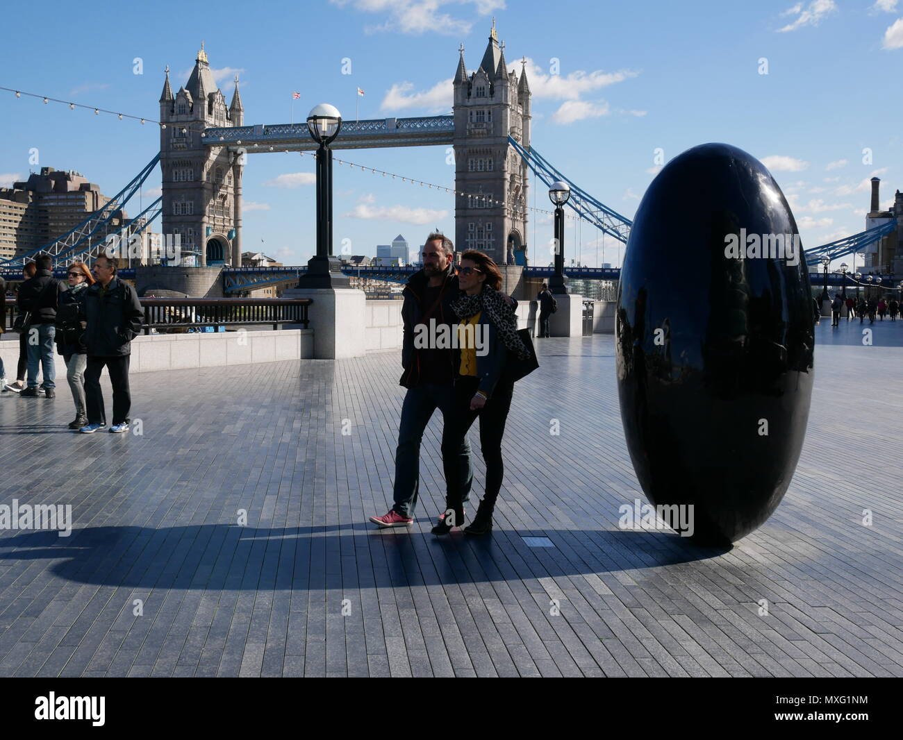 I turisti a fare una passeggiata nei pressi di Tower Bridge in una giornata di sole a Londra, Inghilterra. Foto Stock