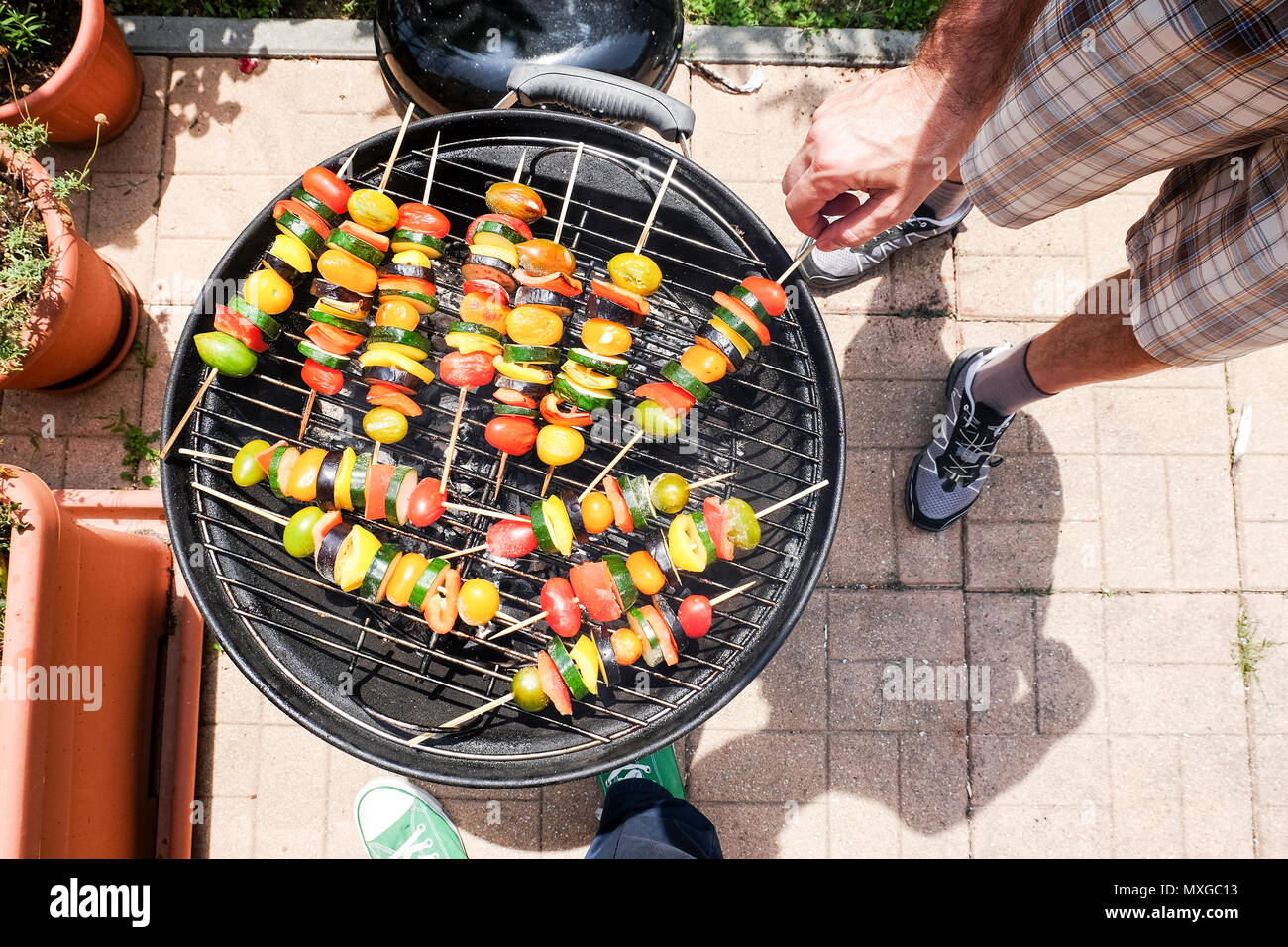 Per la cottura e Grill verdure - zucchine e pomodoro pepeer - gli spiedini su un barbecue all'aperto di un soleggiato weekend rilassante Foto Stock