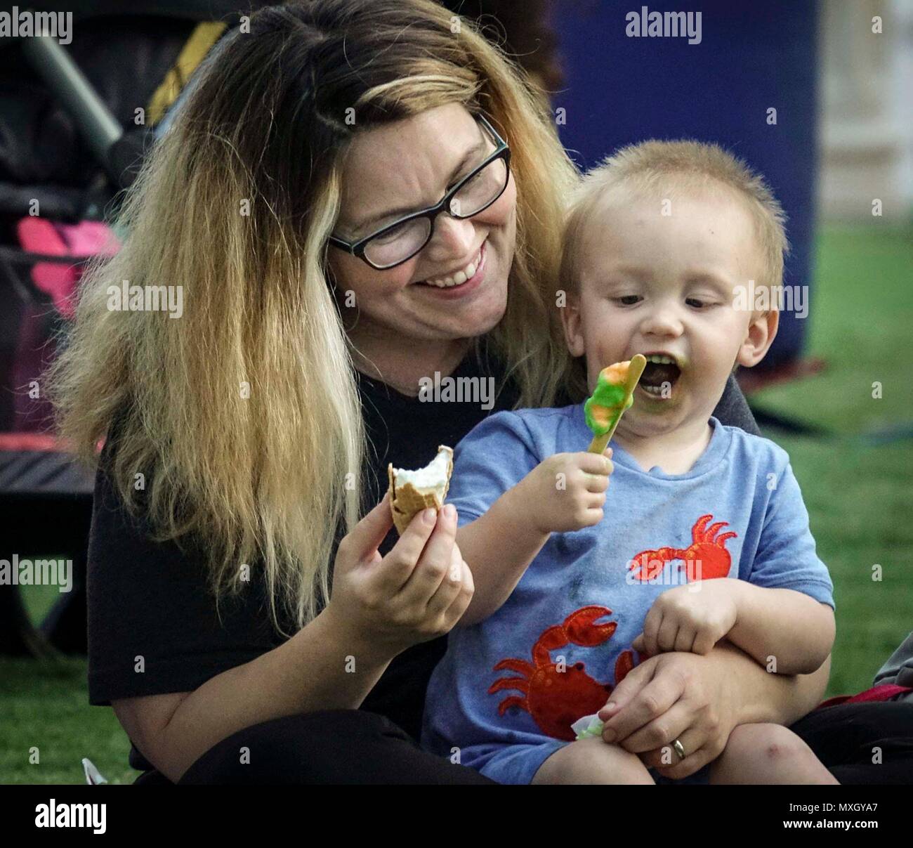 Florida, Stati Uniti d'America. Il 4 giugno, 2018. Due-anno-vecchio Elia Byerly gode di gelato con la madre Leslie a Lake Worth dello schermo sul verde, alla piazza culturale nel centro cittadino di Lake Worth venerdì 1 giugno, 2018. ''Questo è il nostro primo tempo, '' ha detto Leslie. ''Abbiamo appena tornato da Oklahoma. Ci sono così contento di essere tornato indietro." Il film ''Moana'' è stato mostrato. La schermata successiva sul verde si terrà il 3 agosto quando 'Despicable Me 3'' sarà mostrato. Credito: Bruce R. Bennett/Palm Beach post/ZUMA filo/Alamy Live News Foto Stock