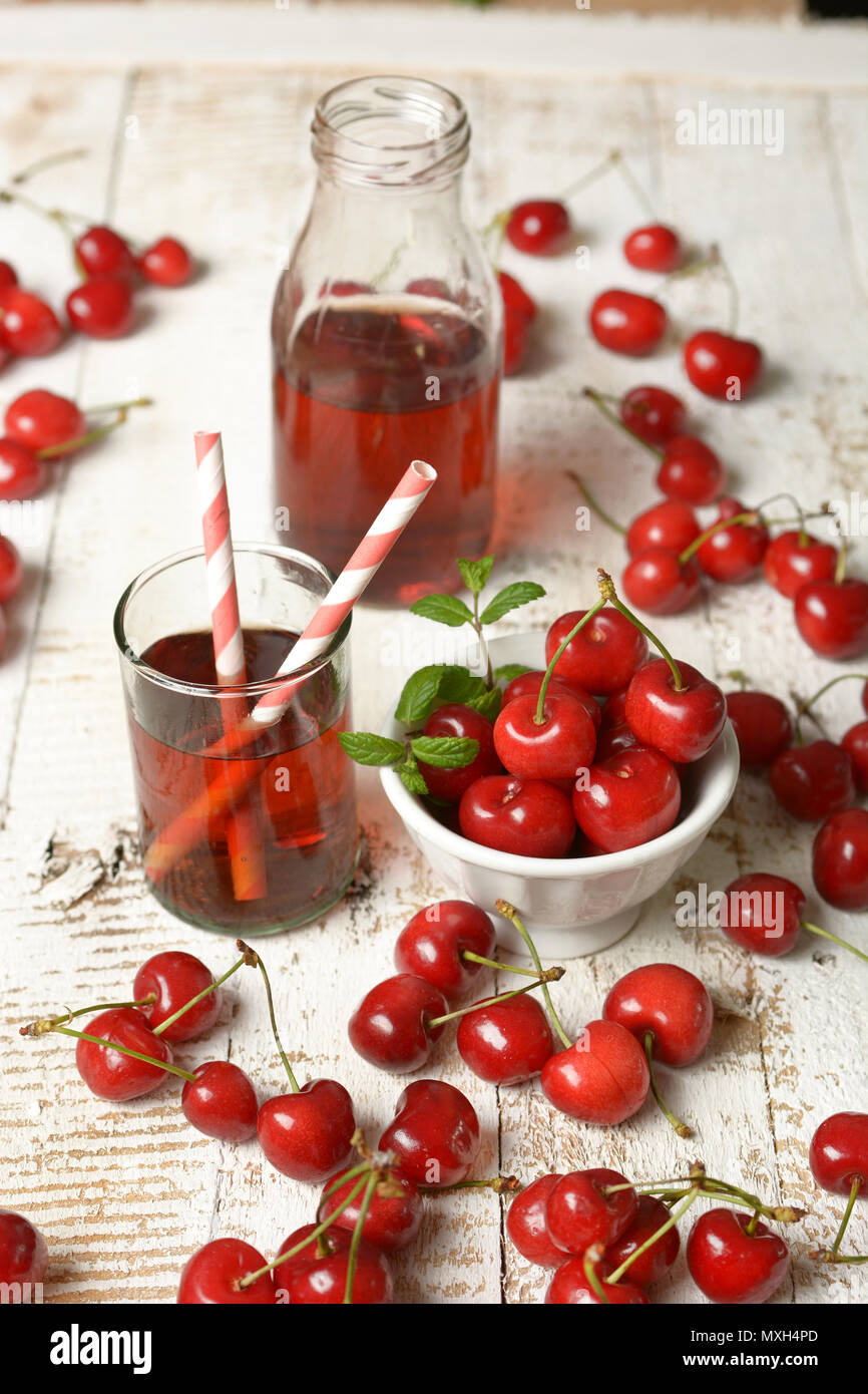 Succhi di ciliegie sul tavolo bianco - primo piano Foto Stock