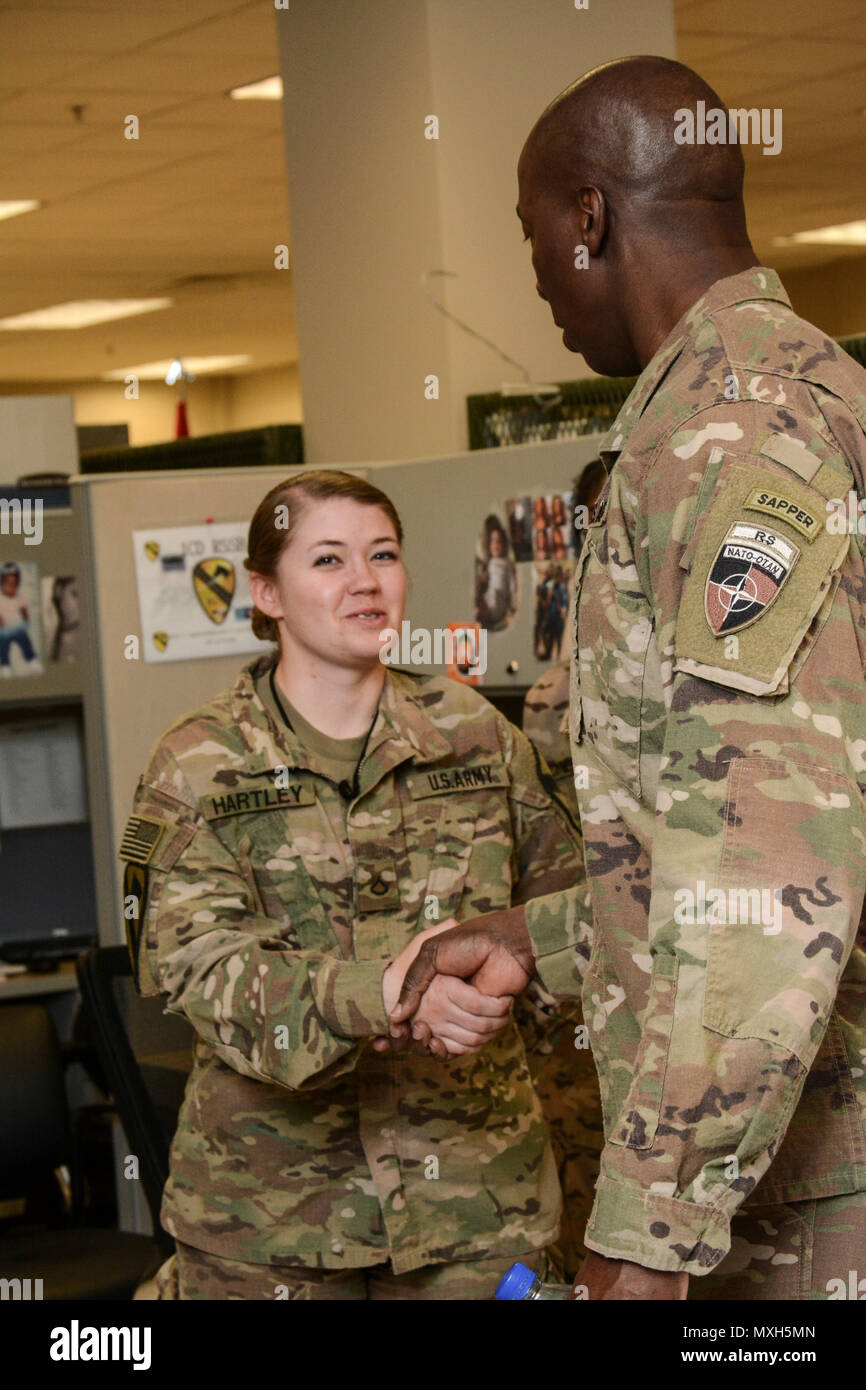 Il comando Sgt. Il Mag. David M. Clark, Senior arruolato per il leader della NATO a sostegno deciso (RS), U.S. Forces-Afghanistan (USFOR-A) presentato PFC Tierra Hartley, Risorse Umane clerk, 1a divisione di cavalleria sostegno deciso supporto brigata, con una moneta durante la sua visita a nov. 5. Foto Stock