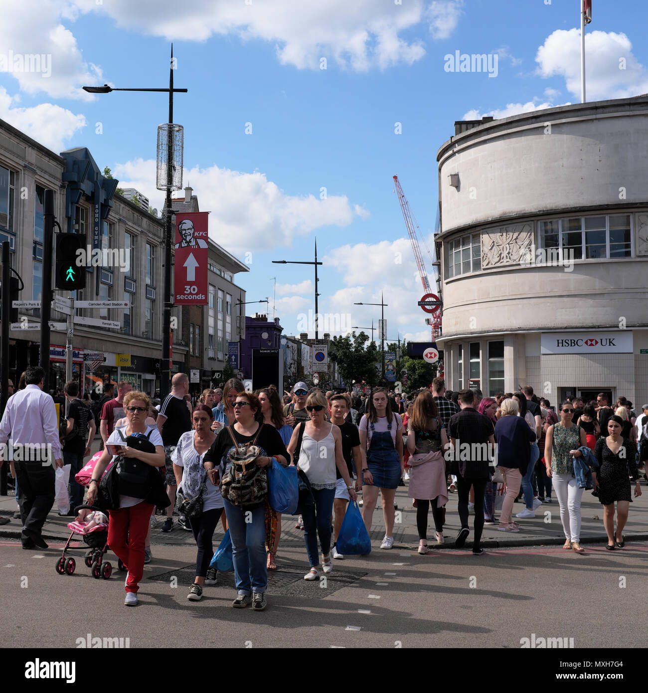Un sacco di persone su strada di attraversamento in Camden, London, England, Regno Unito Foto Stock