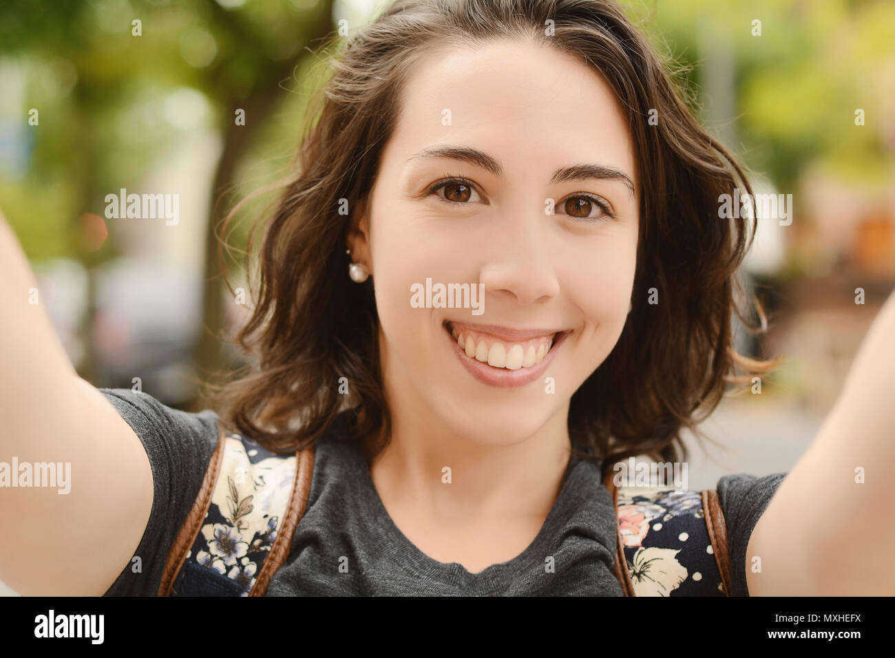 Ritratto di una giovane e bella donna prendendo un selfie nel parco con uno smartphone. Il concetto di stile di vita. All'aperto Foto Stock